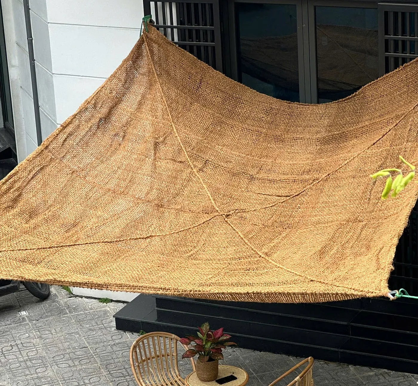 Voile d'ombrage rectangulaire en fibre de coco au-dessus d'un espace extérieur