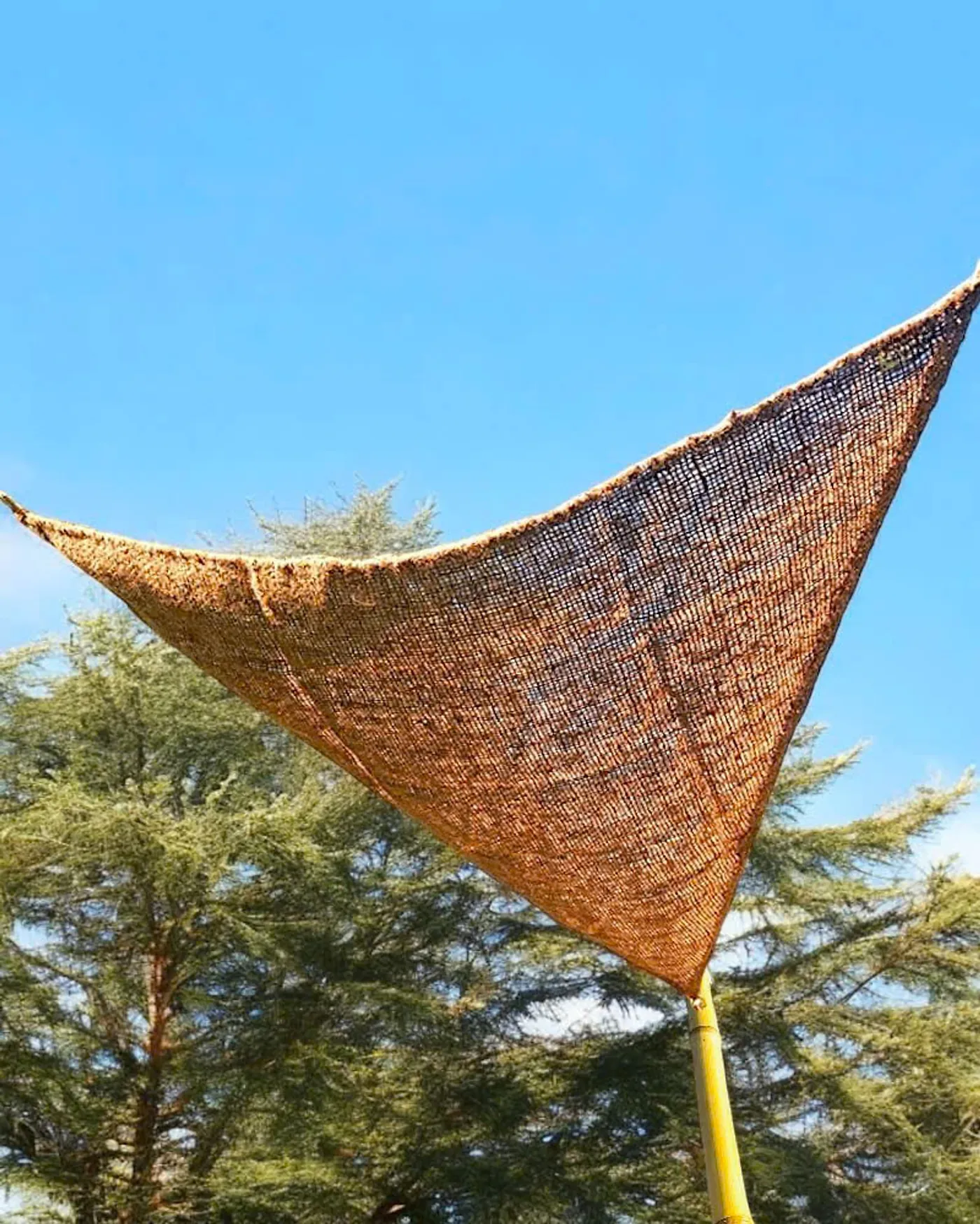 Voile d'ombrage triangulaire en fibre de coco tendue au-dessus d'une terrasse